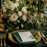Festlicher Hochzeitstisch in Dunkelgrün und Gold mit weißen Blumen
